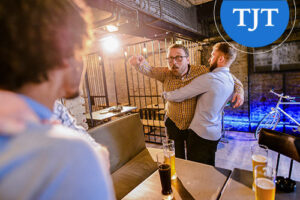 Man restraining another during a bar altercation, illustrating disorderly conduct and simple assault offenses that may be expunged in New Jersey