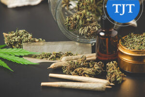 Marijuana buds, rolled joints, cannabis oil, and a grinder on a table, illustrating marijuana and hashish records cleared under New Jersey expungement law